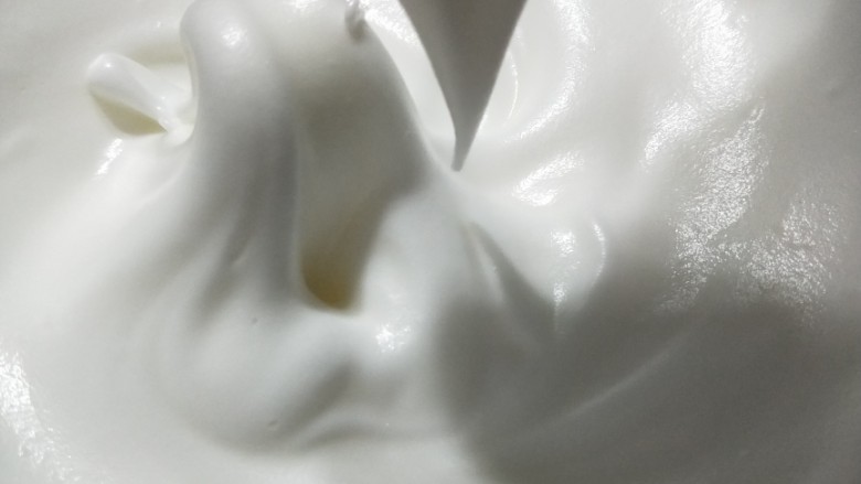 不凹陷纸杯小蛋糕,打发好的蛋白霜是细腻的光泽度明显。（小窍门:关掉打蛋器手动画几圈轻轻提起如图出现三角尖即可。）