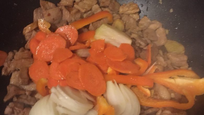 另类回锅肉,加入彩椒、洋葱和过了油的胡萝卜一起从容翻炒，直至酱汁完全被吸收入菜中。