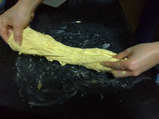 面包入门基本功之黄油面包卷,通过拉扯的方法让黄油尽快揉入面团。