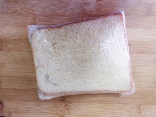 （创意菜）老干妈风味咸鸭蛋酒肠三明治,用保鲜膜紧紧的包裹起来