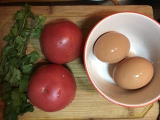一天家西红柿🍅鸡蛋汤,第一步，洗净两个西红柿🍅和两个鸡蛋🥚备用，香菜适量备用。