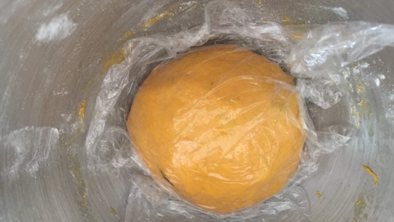 奶香南瓜葡萄干小吐司,盖上保鲜膜发酵至原来的2倍大