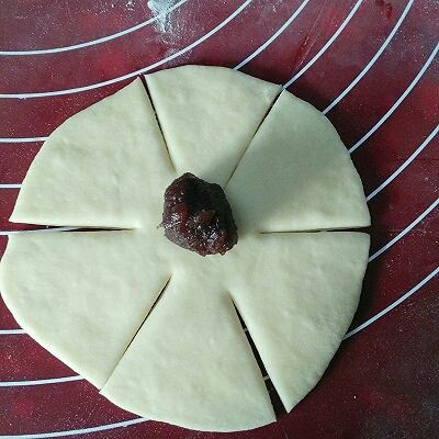 玫瑰面包,取一个面剂擀成圆皮，如图所示划六刀，中间不可划断，在中间部位放上馅料