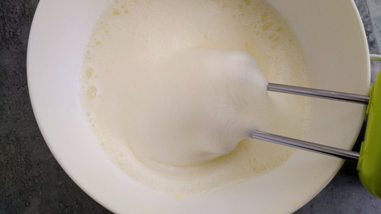 甜品诱惑~棉花纸杯奶油蛋糕,蛋清中加入柠檬汁，用打蛋器打出鱼眼形的大泡，然后加入20克白糖，继续打发