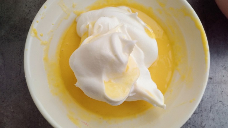 甜品诱惑~棉花纸杯奶油蛋糕, 取出1/3的蛋清和之前拌好的蛋黄混合，用橡皮刮刀拌均匀