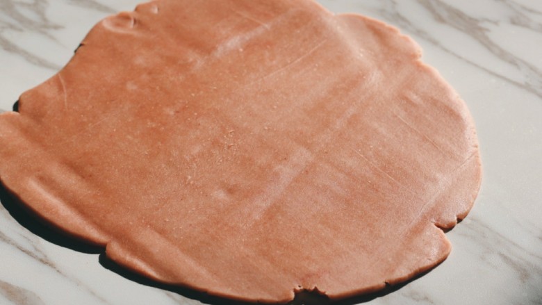 草莓酱夹“心”饼干,取出冷冻的面团，用擀面杖擀成大约5mm厚的薄片。