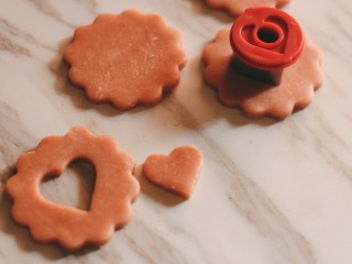 草莓酱夹“心”饼干,用心型模具在其中一半的饼干胚上抠出心形图案。