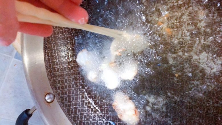 吃掉一朵花+牡丹鱼,油热6-7分时，下鱼片，可以用筷子帮助每一块成花瓣形。不过一般都会自己卷起来的。注意被黏住彼此。