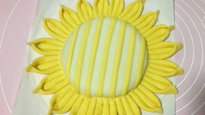 吃掉一朵花+向日葵花馒头,然后把细条竖着贴在白面饼上，每个条条之间相隔的距离要相等。