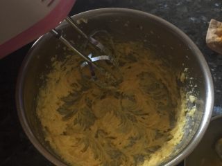 葡萄干奶酥,分两次加入蛋黄液（蛋黄液留一点点最后用，可以不留）搅拌，搅拌至上述混合物至膨松状态，颜色变浅