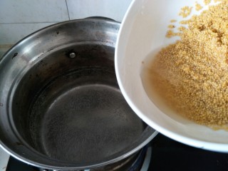 小米南瓜粥,水烧开后放入小米。