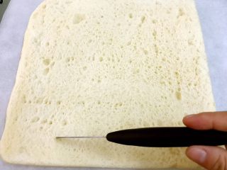 最爱的汤种法香葱肉松面包卷,准备一张油纸，把烤好不太烫手的面包体翻扣在油纸上，用小刀划几刀表面方便卷起（不要划偷啊）