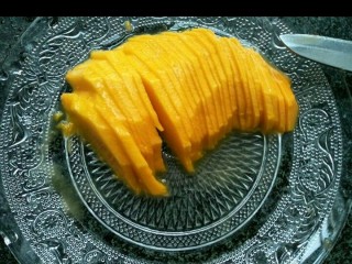 吃掉一朵花+芒果花凉粉,取半边芒果切成薄片。