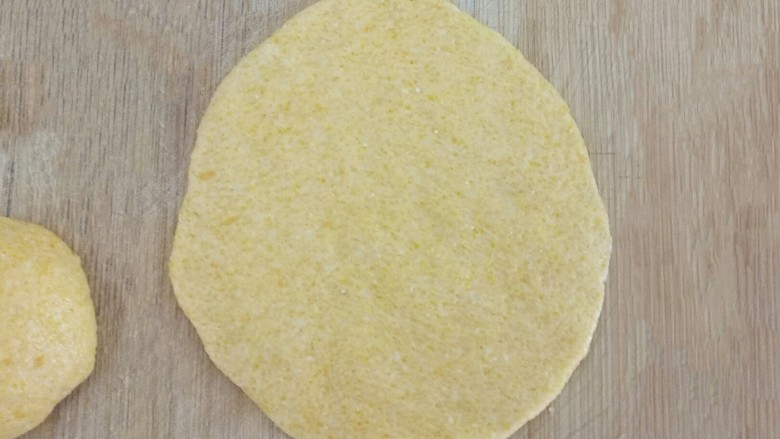橙汁玉米面饼,用手压成光滑的薄薄的面饼