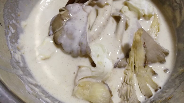 干炸鲜蘑,将腌制一会儿的平菇，放入面糊内，裹上面糊。