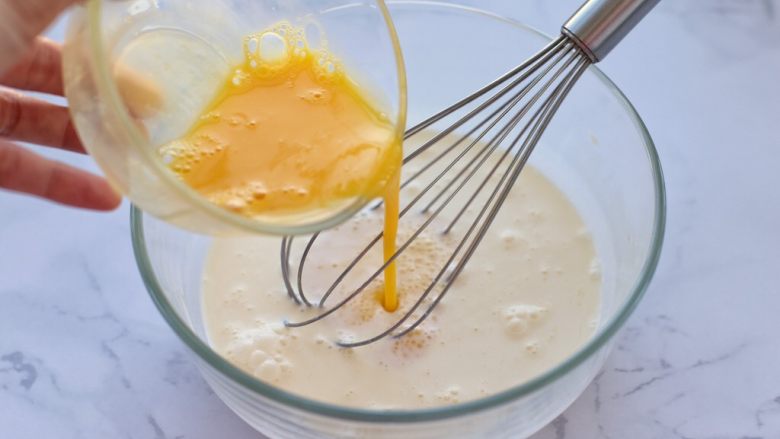奶油红豆派,将打散的蛋液倒入淡奶油中搅拌均匀