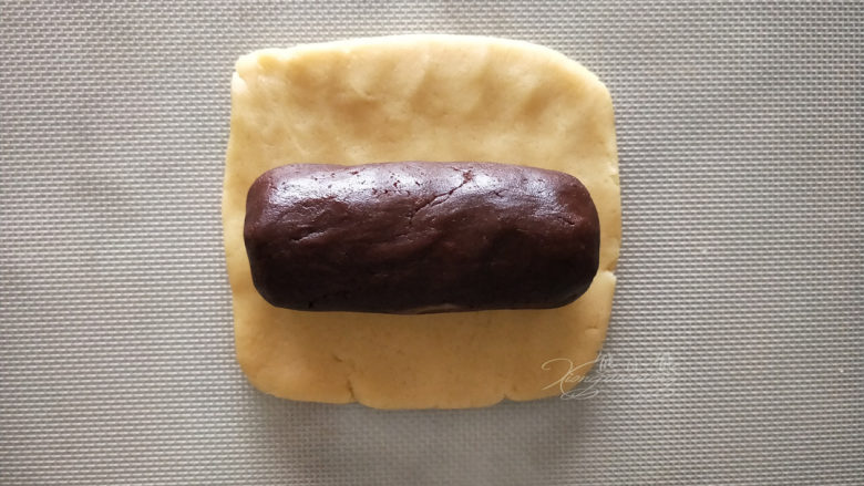 小熊爪印饼干--小盆友都喜欢,把大份的原味面团擀成方形，再将大份的可可面团塑形成相同长度的圆柱体。
