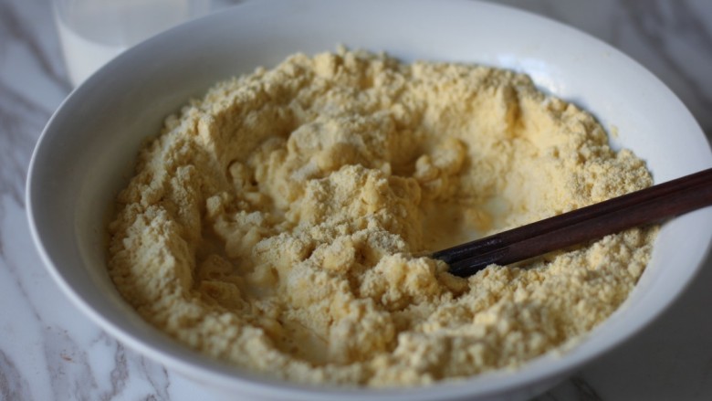 红枣奶香窝头,牛奶分几次缓缓倒入面粉中，用筷子搅拌。