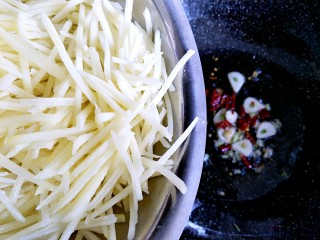 酸辣土豆丝,炒出香味以后把捞出的土豆丝倒入