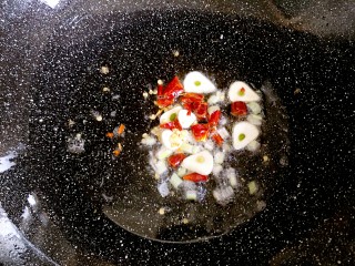 酸辣土豆丝,锅内倒油，下入蒜片辣椒段，和一半的葱末爆香