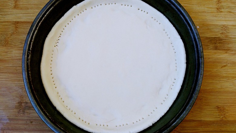 八寸披萨饼饼胚,用叉子把饼边缘扎孔固定。