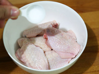 秘制可乐鸡翅,放入食盐，用手拌匀，腌制5分钟