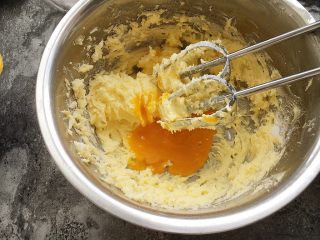 港式菠萝包,软化黄油加糖粉打发蓬松，加入蛋黄继续打发。