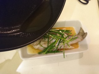 清蒸鱸魚,將油浇淋到魚身上，此時的噼裡啪啦聽起來很過癮。
