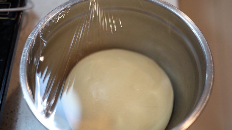 牛角面包--小餐包,盖上保鲜膜，放入发酵箱或者温暖湿润处，发酵至两倍大，用手指沾上面粉戳洞，不回弹不塌陷，这样就可以了