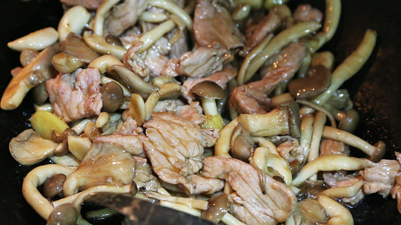 双菇炒肉片,将预先炒至半熟的肉片倒入