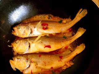 红烧黄鱼,清洗干净 加入适量的油 葱 姜 辣椒油炸出味放入黄鱼 两面煎至金黄倒入黄酒去腥