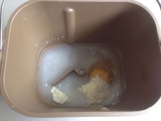 面包机版双味吐司,面包桶里装入水、鸡蛋、糖、盐和奶粉