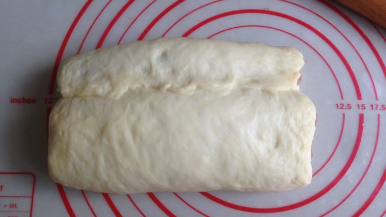 面包机版双味吐司,将白色面团的上部向下盖住可可面团，捏紧收口