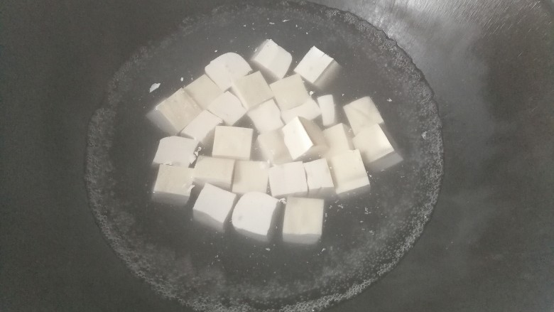 鹌鹑蛋烧豆腐,锅中入适量水烧开，水开后下入豆腐块焯水；