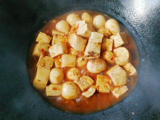 鹌鹑蛋烧豆腐,烧至汤汁变少时，调入适量胡椒与鸡精翻炒均匀；