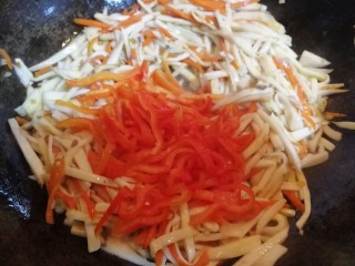 多彩素炒杏鲍菇,炒至杏鲍菇、胡萝卜条变软后，放入红椒条，翻炒一会儿。