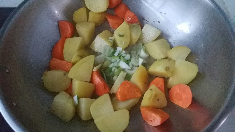 牛窝肉炖土豆,再将胡萝卜块放入继续煸炒，放入葱花炒香