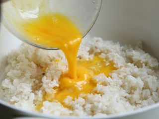 缤纷虾仁蛋炒饭,将打散的蛋液均匀倒入米饭，大火迅速翻炒，使蛋液与米饭相互粘合。