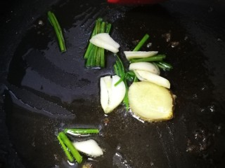 三文鱼头豆腐煲,锅里留底油下葱姜蒜片煸香后弃之。