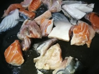 三文鱼头豆腐煲,放入鱼头块煎到两面微黄。。