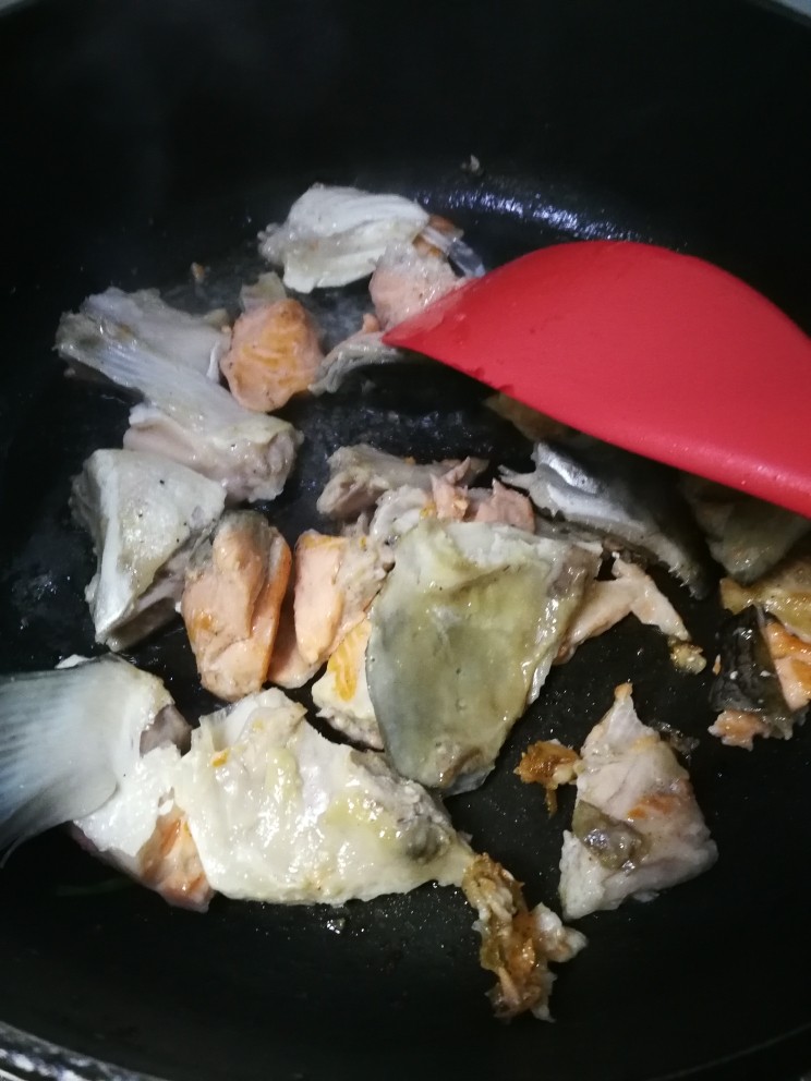 三文鱼头豆腐煲,再倒入鱼头块稍作翻炒。