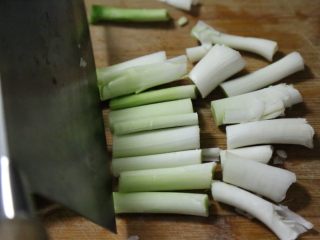 腊肠炒蒜,白色部分用刀拍松，切成长段。