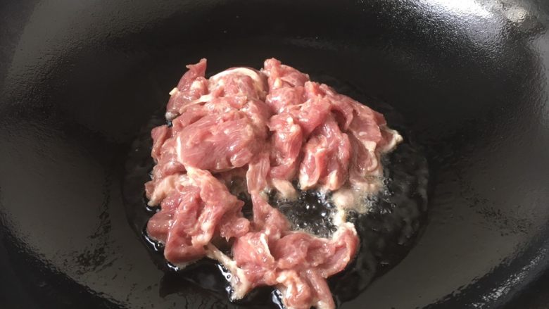 #懒人料理# # 糖醋菜# 葱爆羊肉,锅里放3勺油，当油五、六成热时放入羊肉。