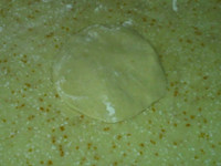 最爱包子+玉米面酸菜小包子,取一个剂子按成中间厚边缘薄的片