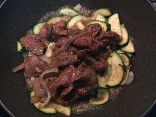 蚝油牛肉炒栉瓜,倒入牛肉片，并加点水在腌牛肉的锅里把剩余的腌料混合一下后，倒入炒锅中，