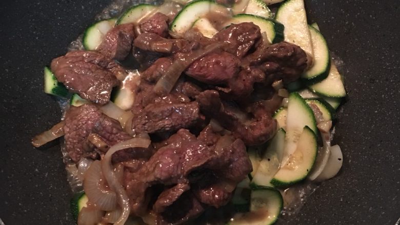 蚝油牛肉炒栉瓜,倒入牛肉片，并加点水在腌牛肉的锅里把剩余的腌料混合一下后，倒入炒锅中，
