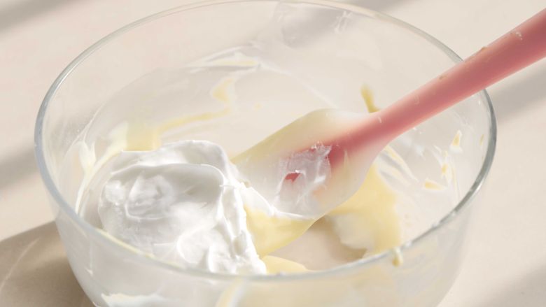 酸奶溶豆（超级详细）,分次加入到酸奶混合泥里翻拌均匀
这里一定是翻拌
切忌画圆的方式
否则就会消泡导致不成形