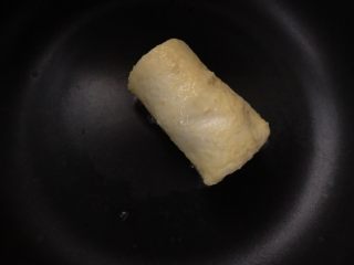 香蕉紫薯吐司卷,平底锅倒少于油，放入裹了蛋液的吐司卷，小火煎