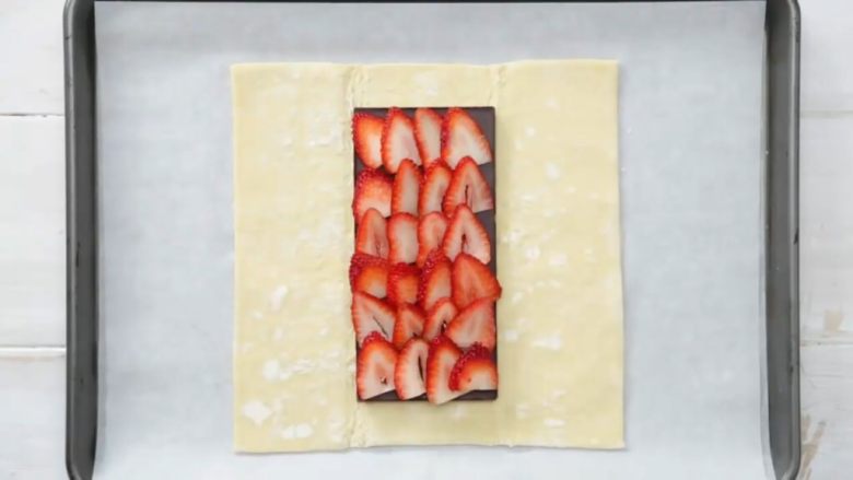 巧克力草莓夹心酥皮面包,将<a style='color:red;display:inline-block;' href='/shicai/ 592'>草莓</a>切片铺在巧克力上。