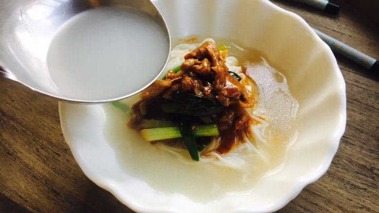 #懒人料理# 香葱羊肉米线,盛入适量的米线汤。